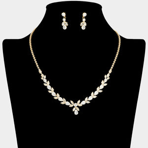 Clear crystal delicate necklace set on gold with alternating marquise stones, a small center drop, and matching drop earrings, displayed on a black jewelry bust.