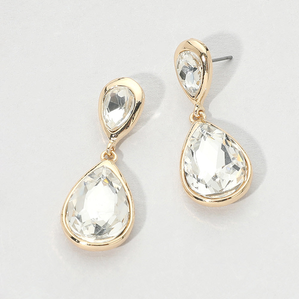 Gold-tone drop earrings with faceted clear double teardrop crystals, displayed on a clean white background.