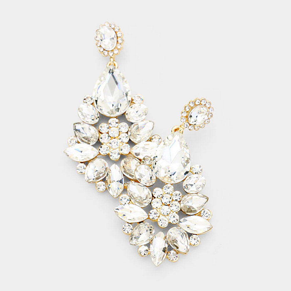 Floral teardrop earrings with clear crystals on gold, featuring oval crystal tops, large teardrops, and flower clusters with petal-shaped stones, displayed on white marble.