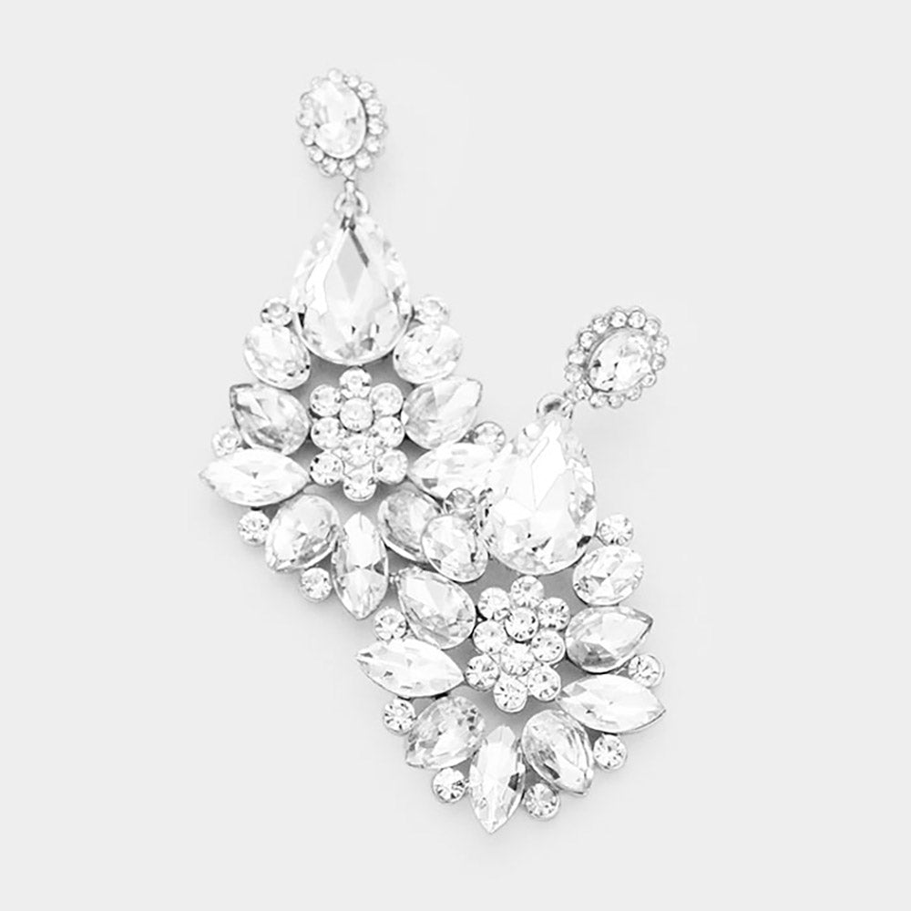 Floral teardrop earrings with clear crystals on silver, featuring oval crystal tops, large teardrops, and flower clusters with petal-shaped stones, displayed on white marble.