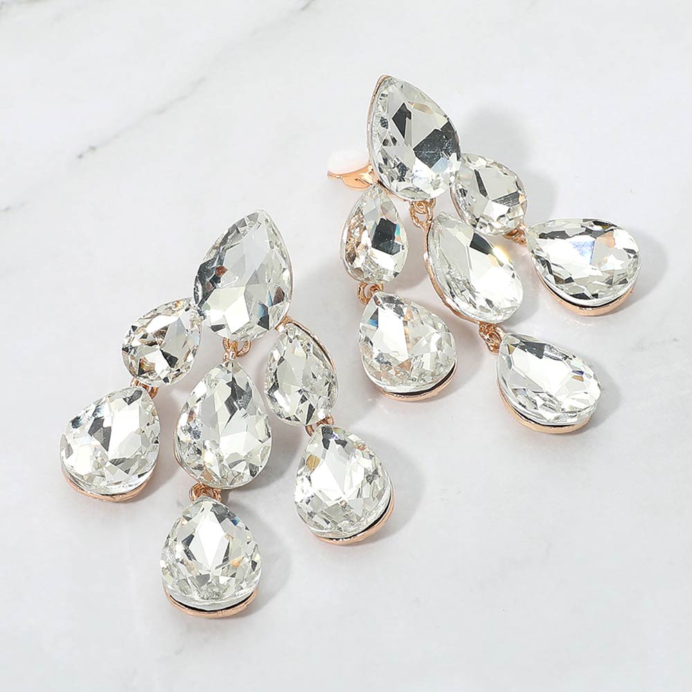 Clear crystal teardrop cluster chandelier clip-on earrings on gold on white marble background