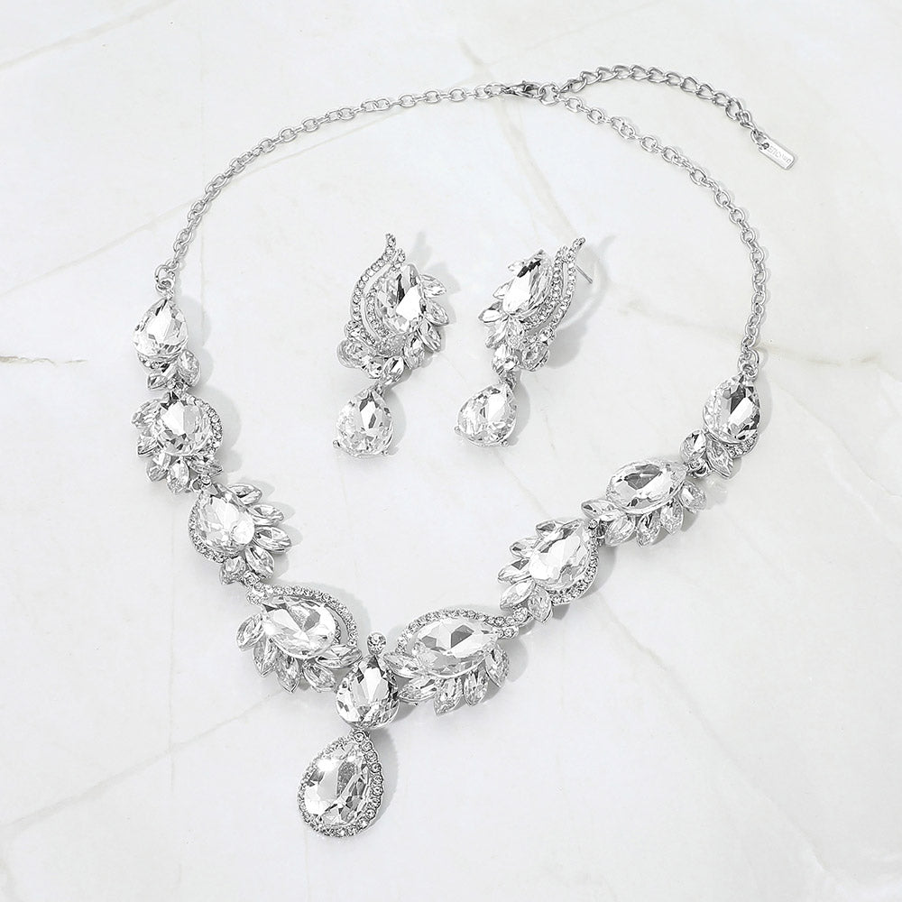 Clear crystal teardrop formal necklace and matching earrings set on silver displayed on a white background.