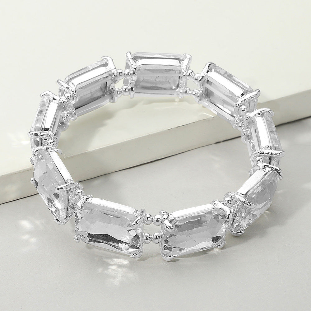 A silver-tone stretch bracelet featuring rectangular clear emerald-cut crystals in a single row, displayed on a light background.