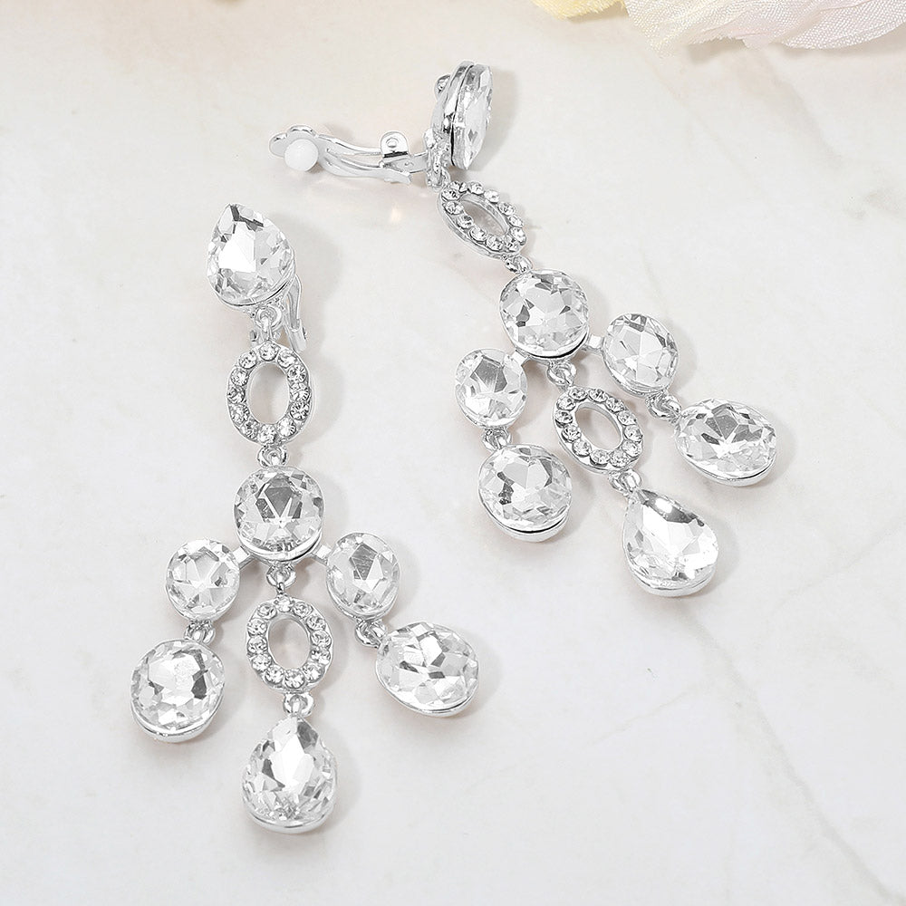 Clear faceted chandelier clip-on earrings with cascading dangle stones and silver-tone setting on a marble background