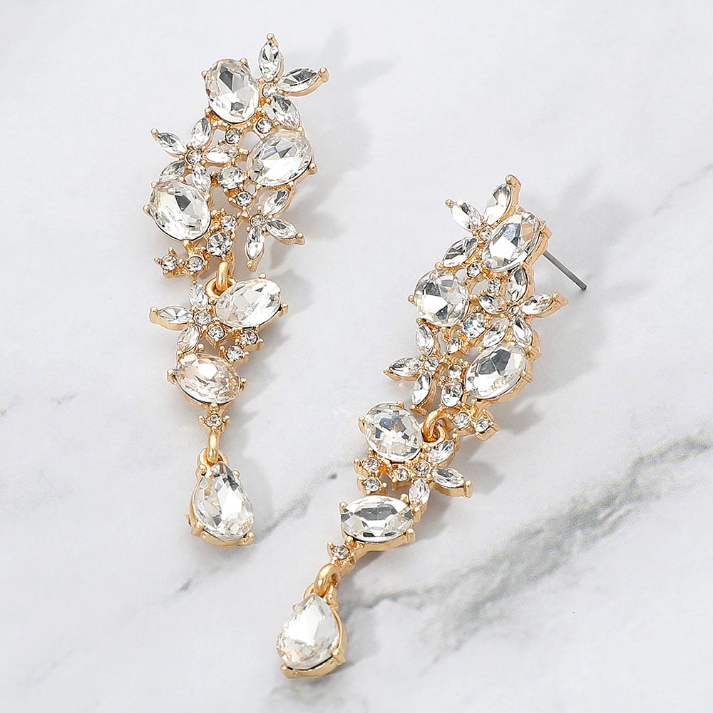 Clear floral crystal cluster earrings on gold with marquise and oval stones for wedding or evening elegance on a marble background