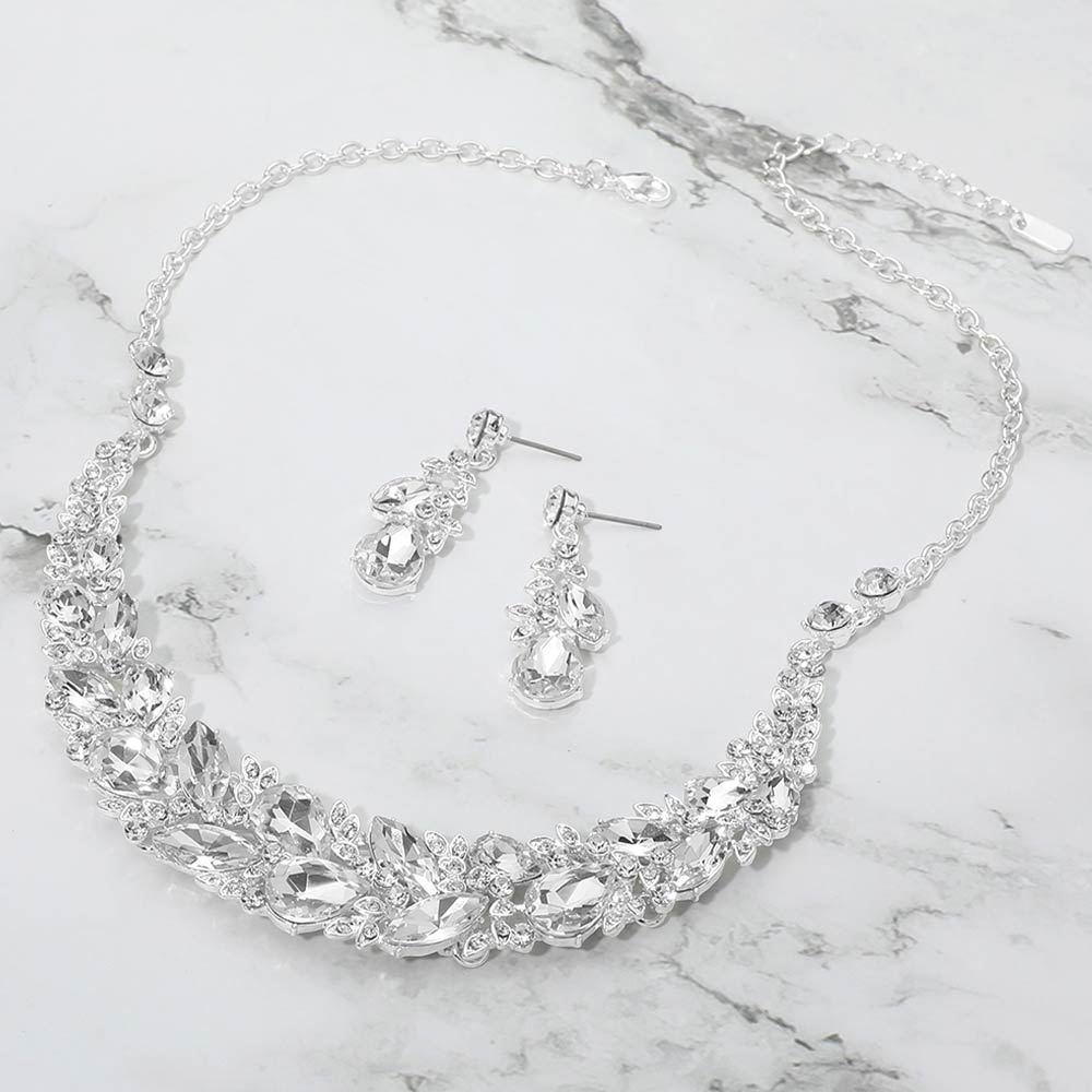 Clear marquise crystal cluster necklace set on silver with matching earrings, elegant statement jewelry for prom and evening wear on a marble background