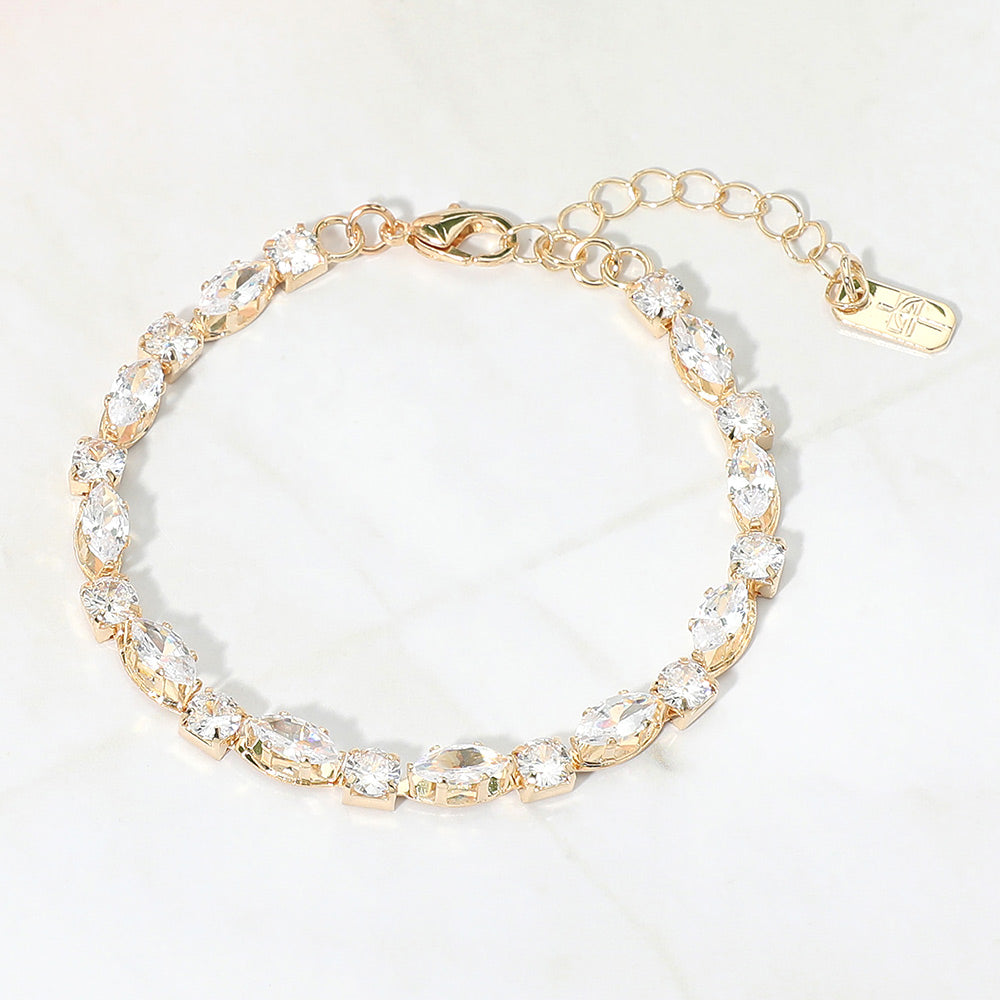 Clear marquise crystal prom bracelet on gold on white marble background