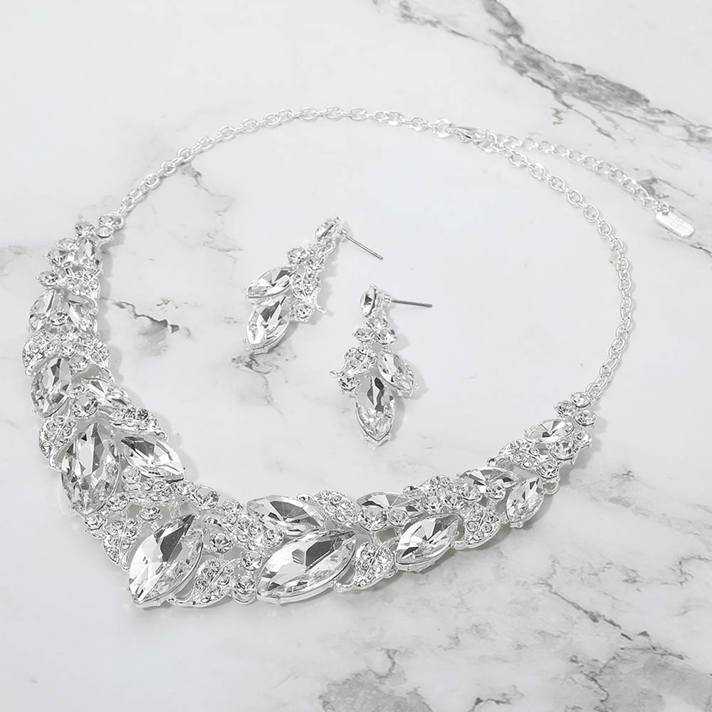 Clear marquise leaf crystal necklace set on silver with matching earrings, elegant statement jewelry for prom and evening wear on a marble background