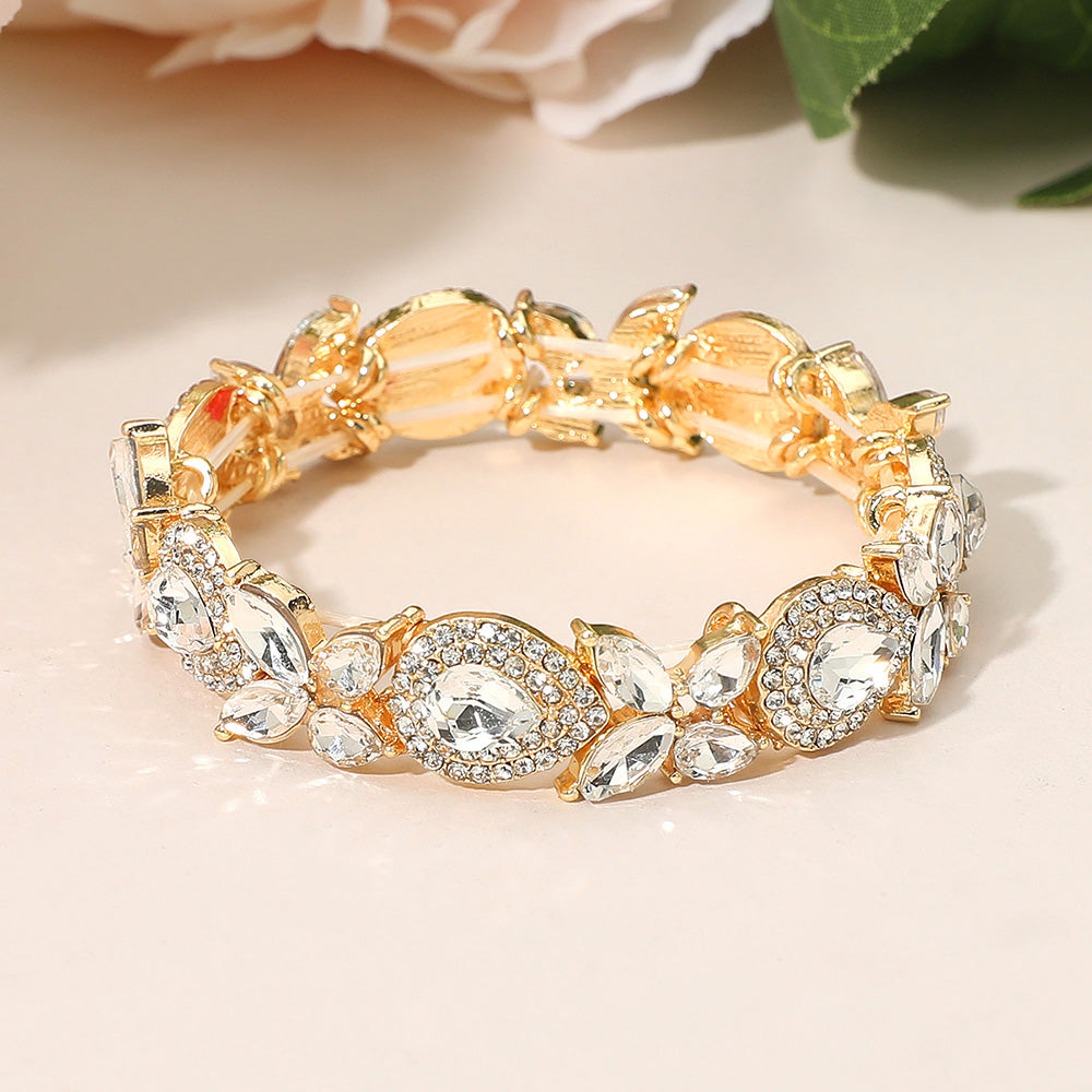 Clear rhinestone marquise bracelet on gold stretch band for weddings or pageants on a peach background