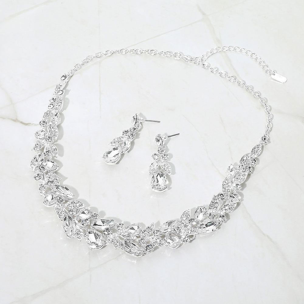 Clear marquise and teardrop crystal cluster formal necklace set on silver with matching earrings on white marble background