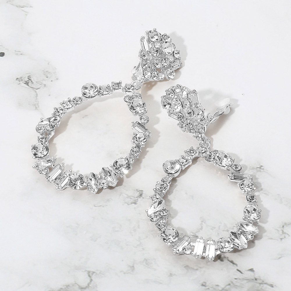 Clear mixed stone cluster open teardrop clip-on pageant earrings on silver on a white background