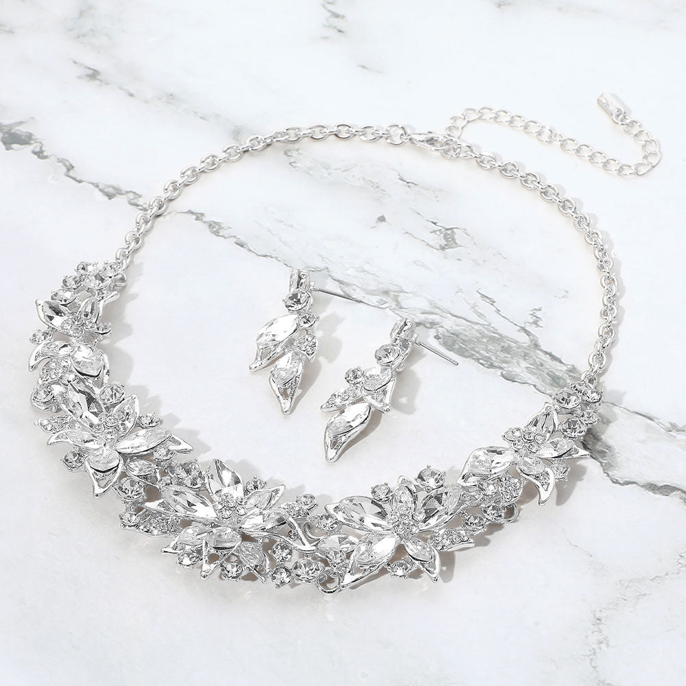 Clear multi shape stone collar-bib necklace set with matching earrings for homecoming, pageants, or formal occasions on a grey and white granite background