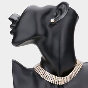 5-row Clear crystal choker necklace and matching round stud earrings on gold-tone metal. Multiple closely spaced crystal rows form a 0.6-inch-high band; the necklace measures 12.5 inches plus a 4.25-inch extender, and the studs measure 0.3 inches. Shown on a black mannequin bust with one stud visible, against a light gray background.
