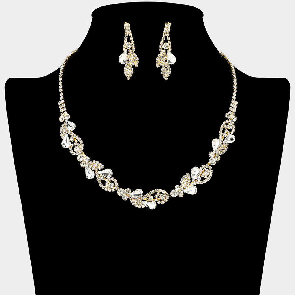 Clear rhinestone leaf cluster necklace set with teardrop crystal earrings, gold backed, for prom and evening wear on a black mannequin bust.