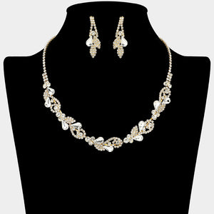 Clear rhinestone leaf cluster necklace set with teardrop crystal earrings, gold backed, for prom and evening wear on a black mannequin bust.
