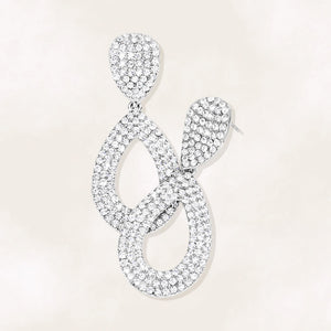 Clear rhinestone pavé cut out teardrop pageant and formal earrings on silver on a beige background
