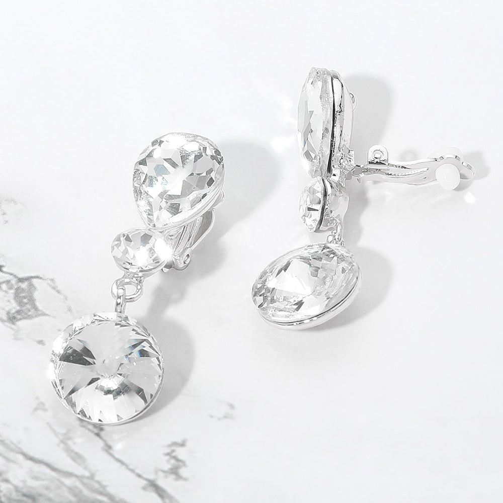 Clear round crystal drop clip-on earrings on silver on white marble background