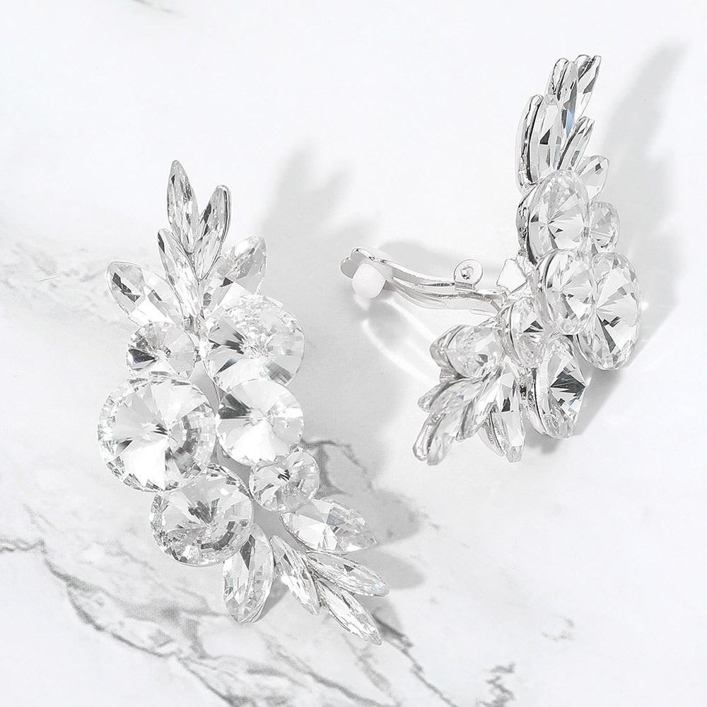 Clear crystal cluster floral statement clip-on earrings on silver on a white marble background