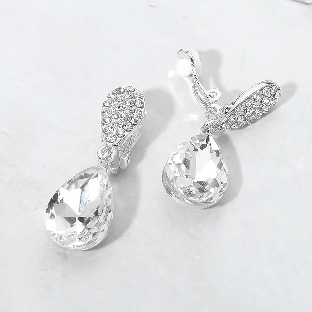 Clear teardrop crystal drop clip-on earrings on silver on white marble background