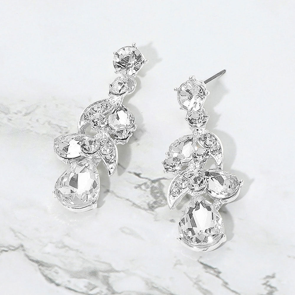 Clear teardrop crystal cluster drop prom and formal earrings on silver on white marble background