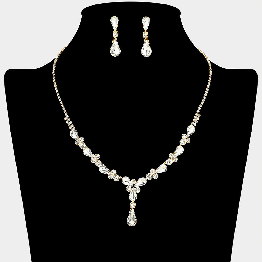 Clear teardrop crystal necklace set on gold with matching earrings for prom and evening wear on a black mannequin bust on a white background.