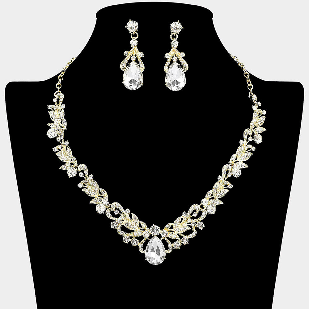 Clear crystal teardrop leaf necklace and earring set on gold styled for prom or evening wear, shown on a black mannequin bust on a white background