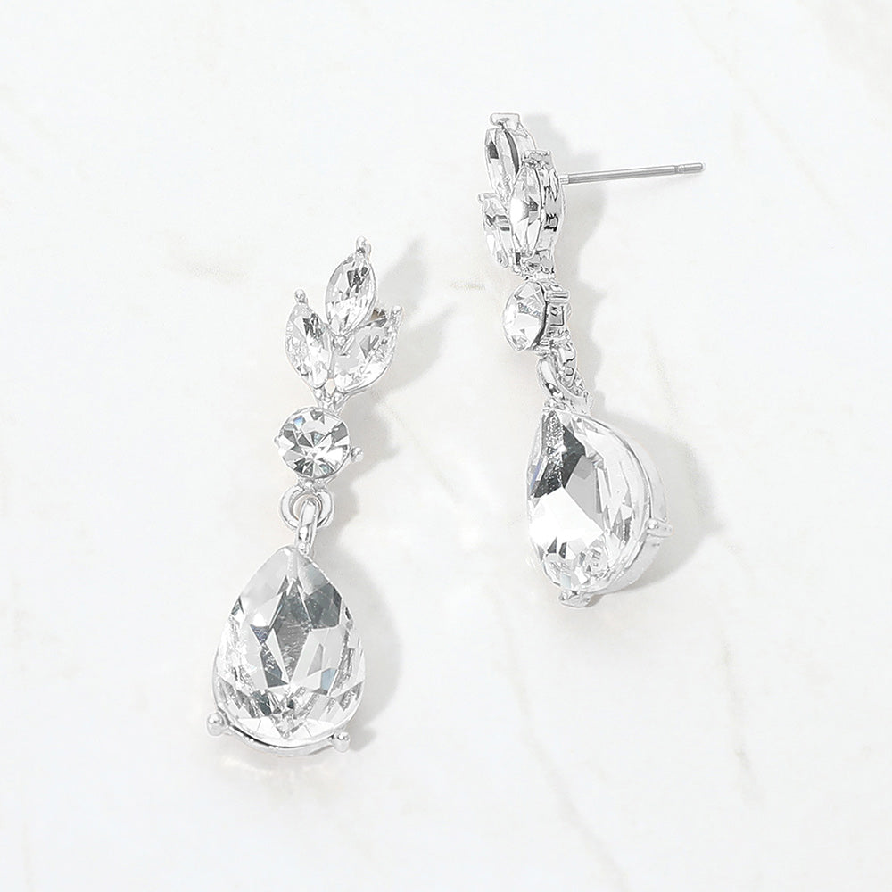 Clear crystal teardrop earrings on silver with large pear-shaped bottom crystals and smaller marquise and round crystal accents, displayed on a white background.