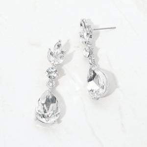 Clear crystal teardrop earrings on silver with large pear-shaped bottom crystals and smaller marquise and round crystal accents, displayed on a white background.
