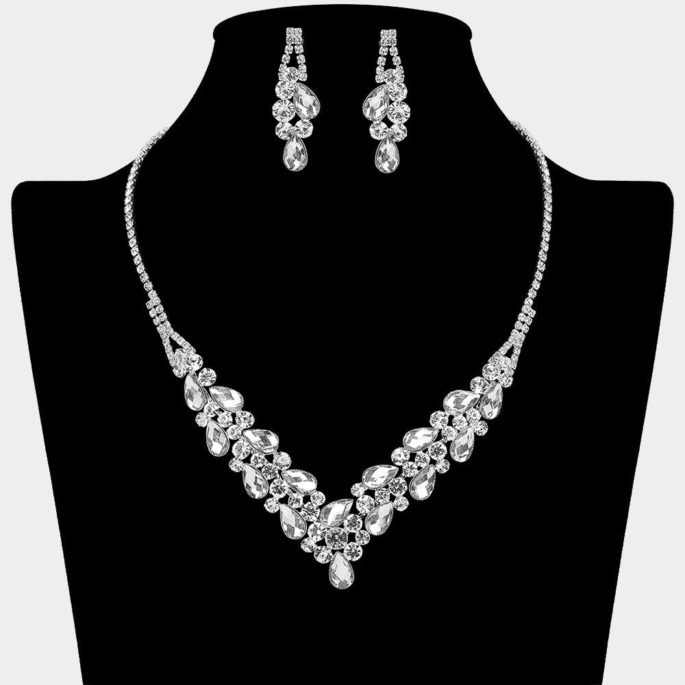 Clear teardrop rhinestone necklace set with V-shaped crystal design and matching earrings, all backed in silver, for prom and formal wear. Shown on a black mannequin bust.  