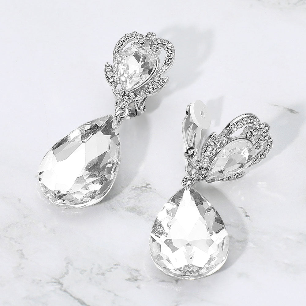 Clear faceted teardrop stone clip-on earrings on silver. Top stone is elegantly surrounded by an array of rhinestones in a flower like setting. 