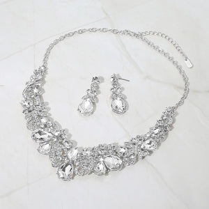Clear teardrop floral statement necklace set on silver displayed on white background