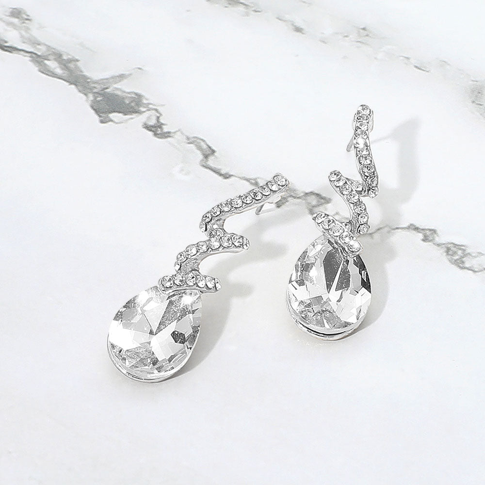 Clear teardrop swirl crystal earrings for little girls pageant or beauty walk wear on a white background.