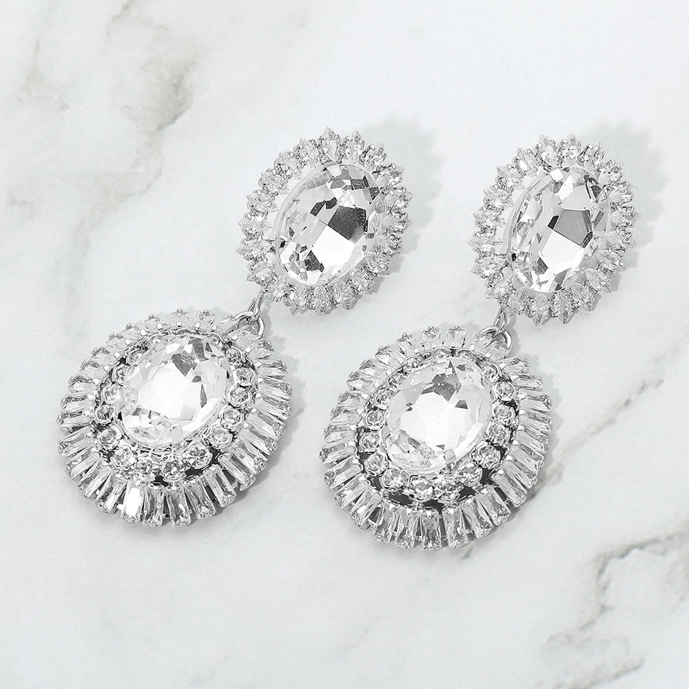 Clear vintage double oval crystal statement earrings in a silver finish featuring two oval clear crystals surrounded by sparkling crystal halos, displayed on a white marble background.