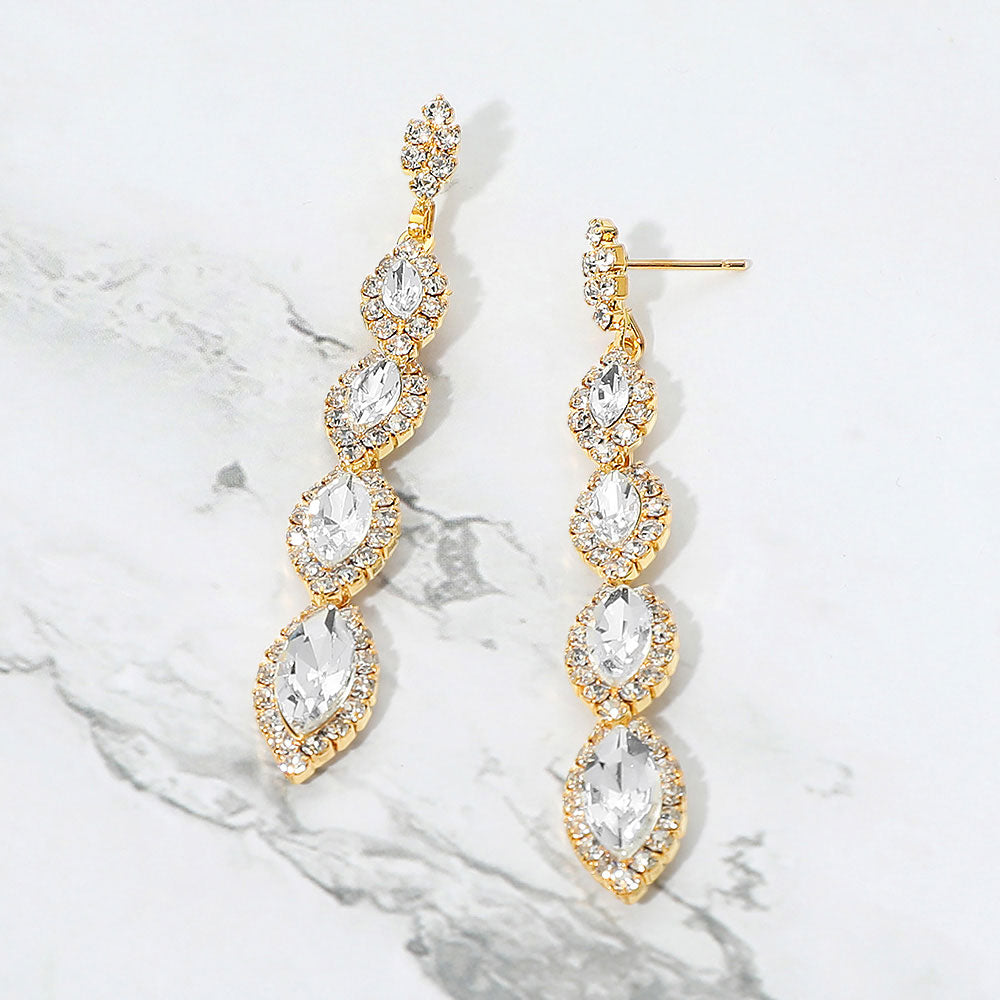 Clear vintage marquise stone link drop formal evening earrings on gold with rhinestones on white marble background