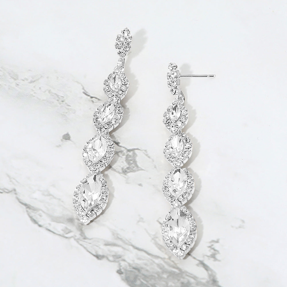 Clear vintage marquise stone link drop formal evening earrings on silver with rhinestones on white marble background