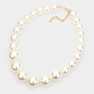 Cream oversized pearl statement necklace set with large round pearl beads and matching earrings, displayed on a light cream background.