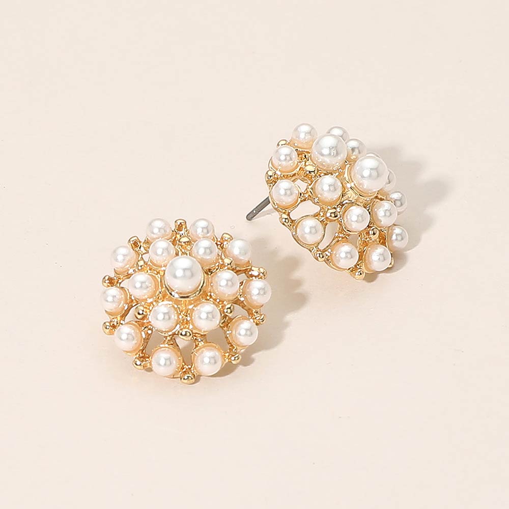 Cream pearl cluster stud earrings on gold on beige background