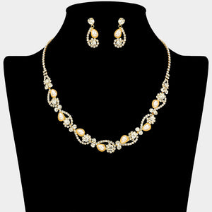 Cream pearl and clear crystal bridal necklace set on gold with alternating pearl and crystal accents and matching drop earrings, displayed on a black jewelry bust.