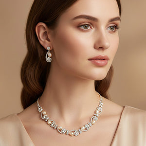 Model wearing cream pearl and clear crystal bridal necklace set on gold with alternating pearl and crystal accents and matching drop earrings.