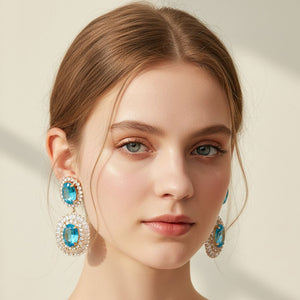 Model wearing the same vintage double oval statement earrings shown in an aqua crystal and gold finish, demonstrating the size and fit when worn.