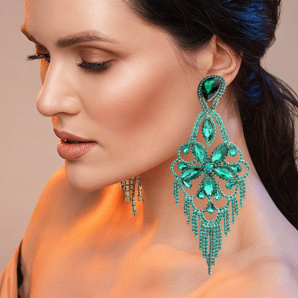 Very large emerald green crystal flower fringe pageant earrings on gold worn by model for pageant styling