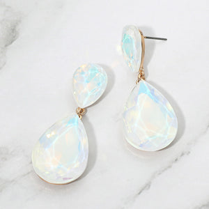 White opal crystal double teardrop dangle earrings on gold displayed on a white marble background.