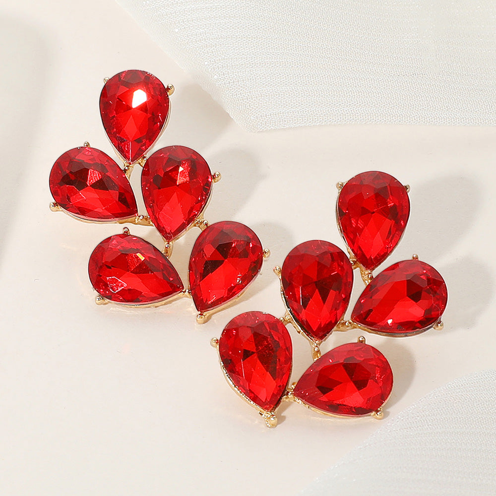 Red crystal teardrop cluster earrings on gold for pageants or formal events on a light background.