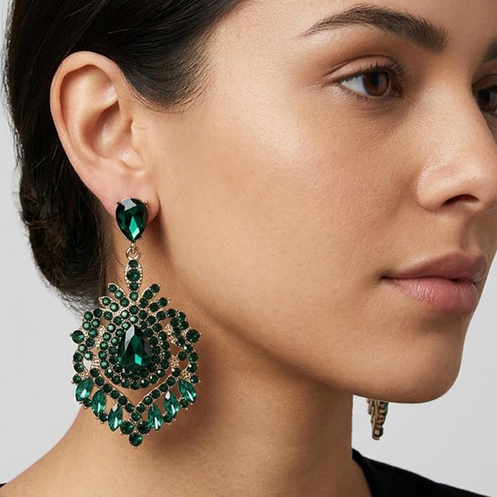 Model wearing Emerald Green crystal teardrop chandelier statement pageant earrings on gold with an ornate layered crystal design.