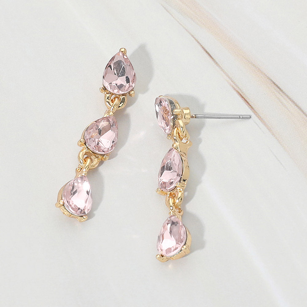 Small light pink triple teardrop cluster drop earrings on gold on a white marble background