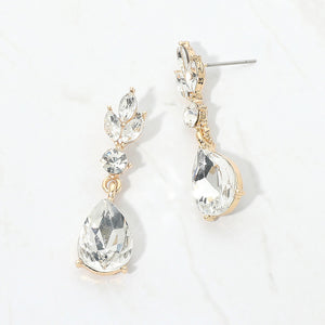 Clear crystal teardrop earrings on gold with a large pear-shaped bottom crystal and smaller marquise and round crystal accents, displayed on a white background.