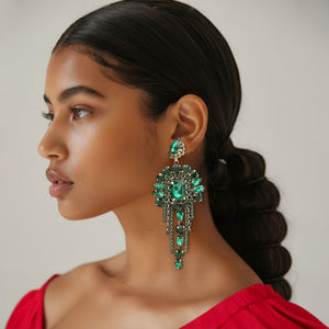 Long 4.6" emerald green chandelier fringe earrings on gold on a pretty lady on a white background — dramatic crystal statement jewelry for pageant, prom, weddings, and evening events.