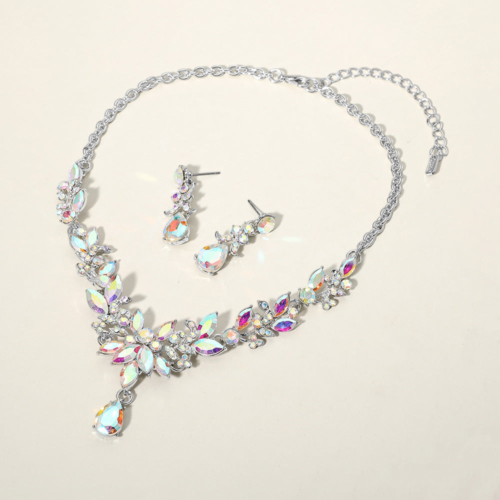 AB crystal teardrop and marquise leaf necklace set on silver with matching earrings, iridescent statement jewelry for bridal, prom, and evening wear on a beige background