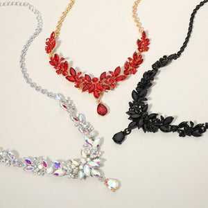 crystal teardrop and marquise leaf necklace sets shown together here in AB, red and black  for prom and evening wear on a beige background