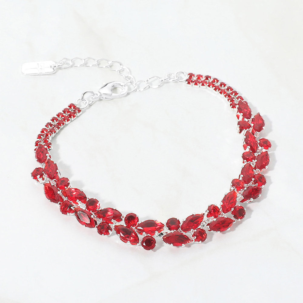 Red multi-shape crystal bracelet on silver with marquise and round crystal accents and an extender chain, displayed on a white background.